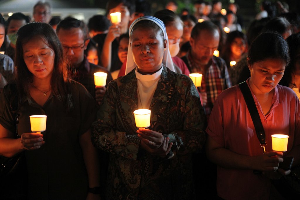 Umat Katolik memegang lilin dan berdoa di Gereja Katedral Hati Kudus Yesus, Surabaya, Jawa Timur, Sabtu (26/4/2025). Doa bersama dengan menyalakan lilin yang diikuti ratusan umat Katolik itu untuk mendoakan mendiang Pemimpin Tertinggi Gereja Katolik Sedunia Paus Fransiskus. ANTARA FOTO/Didik Suhartono/rwa. Doa bersama untuk Paus Fransiskus