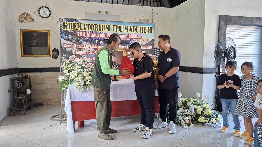 Ratri dan Bagus, anak Hamzah Sulaiman alias Raminten, saat menerima penyerahan abu jenazah sang ayah di Krematorium TPU Madurejo, Kabupaten Sleman, pada Sabtu (26/4/2025). Tirto.id/Siti Fatimah Krematorium Hamzah Sulaiman