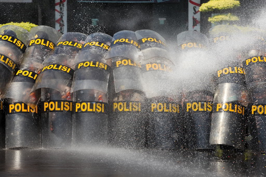 Sejumlah anggota Polri dengan tameng disemprot air dari water canon untuk menguji kekuatan barikade saat mengikuti latihan pengendalian massa pengunjuk rasa di Polrestabes Surabaya, Surabaya, Jawa Timur, Selasa (29/4/2025). ANTARA FOTO/Didik Suhartono/oc. Latihan pengendalian massa pengunjuk rasa