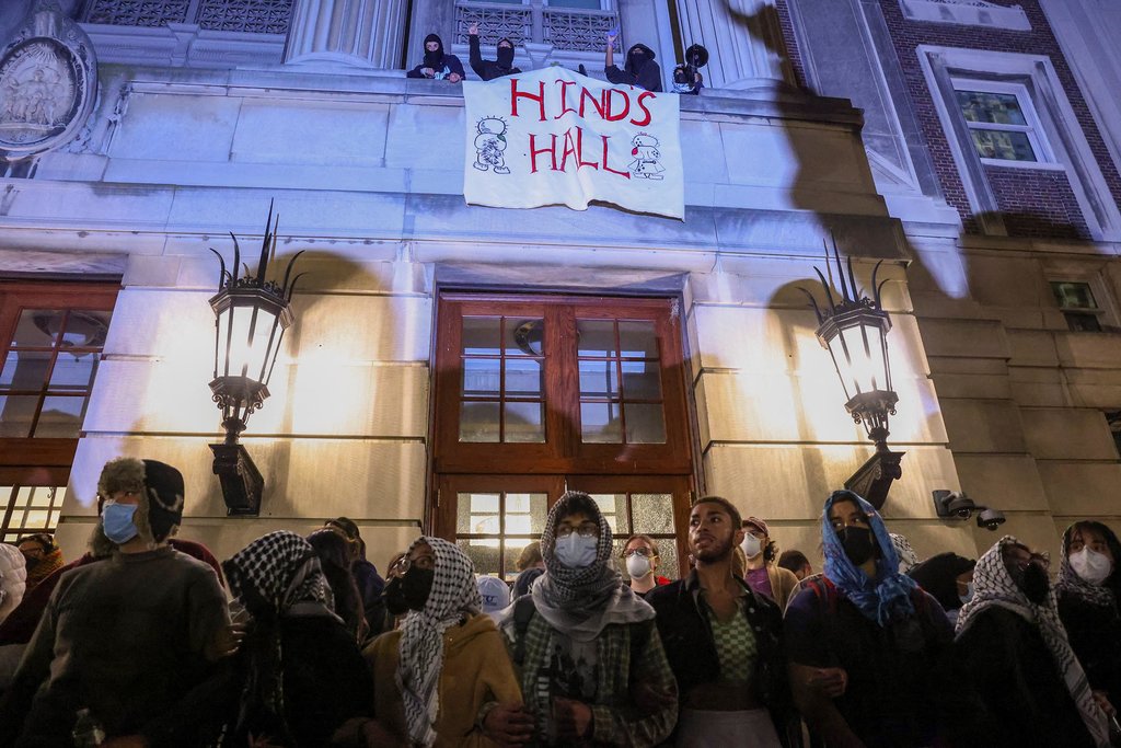 Para pengunjuk rasa saling bergandengan tangan di luar Hamilton Hall untuk menghalangi para mahasiswa di dalam gedung di Universitas Columbia, meskipun ada perintah untuk membubarkan perkemahan protes yang mendukung warga Palestina atau menghadapi penangguhan, selama konflik yang sedang berlangsung antara Israel dan kelompok Islam Palestina Hamas, di New York City, AS, 30 April 2024. REUTERS/Caitlin Ochs Hamilton Hall