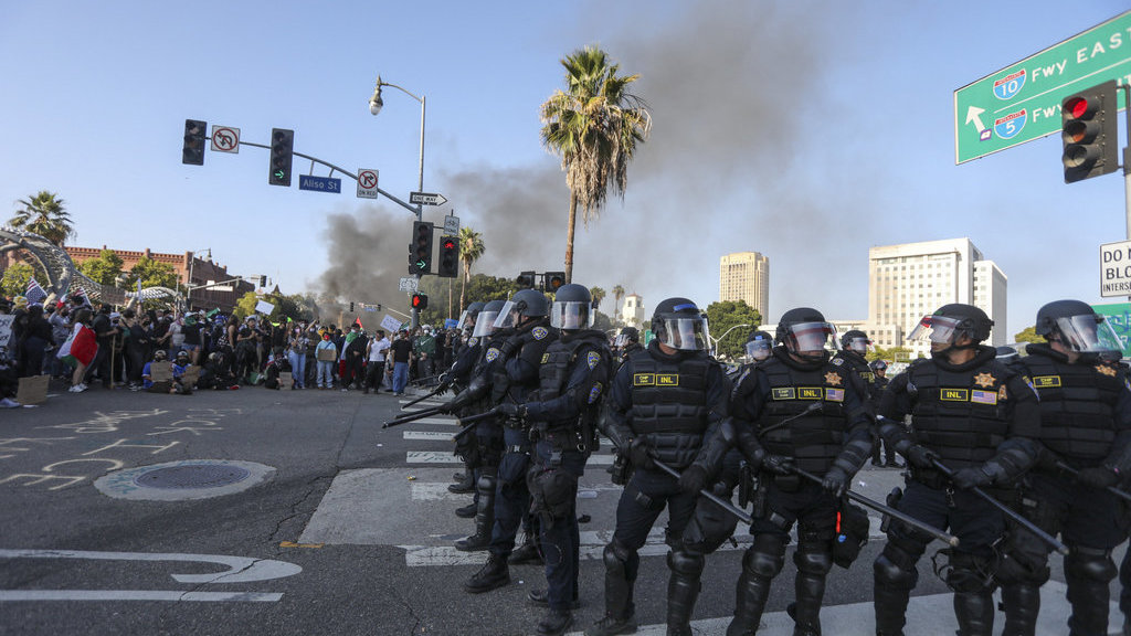 Demonstran bentrok dengan aparat penegak hukum di jalan-jalan sekitar gedung federal selama protes menyusul operasi imigrasi federal di Los Angeles, California, pada 8 Juni 2025. Demonstran membakar mobil dan bentrok dengan pasukan keamanan di Los Angeles pada 8 Juni, saat polisi menjauhkan pengunjuk rasa dari pasukan Garda Nasional yang dikirim Presiden Donald Trump ke jalan-jalan kota terbesar kedua di AS tersebut. (Photo by RINGO CHIU / AFP) Kerusuhan di Los Angeles