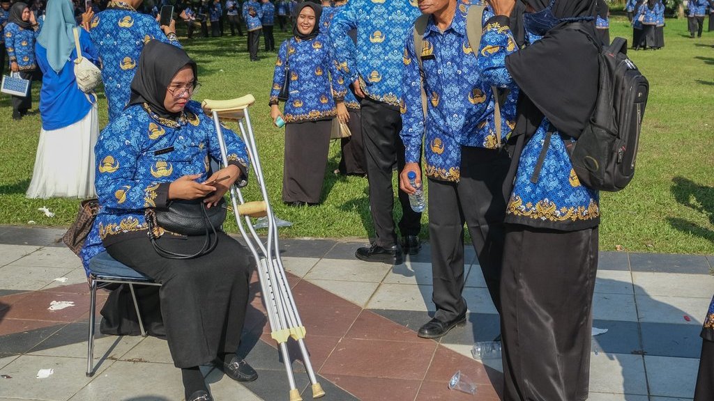 Seorang Calon Pegawai Negeri Sipil (CPNS) memegangi tongkatnya setelah menerima SK pengangkatan di halaman Kantor Gubernur Sultra, Kendari, Sulawesi Tenggara, Senin (16/6/2025). ANTARA FOTO/Andry Denisah/foc. Penyerahan SK CPNS dan PPPK di Kendari