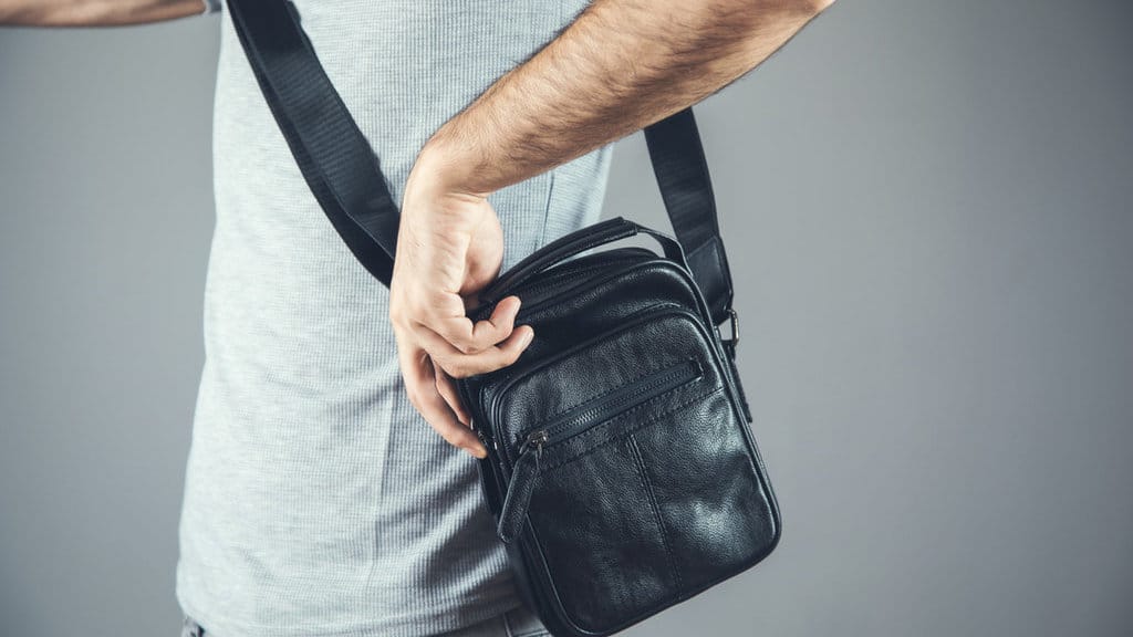 Ilustrasi Pria Memakai Tas Selempang. FOTO/iStockphoto Ilustrasi Pria Memakai Tas Selempang