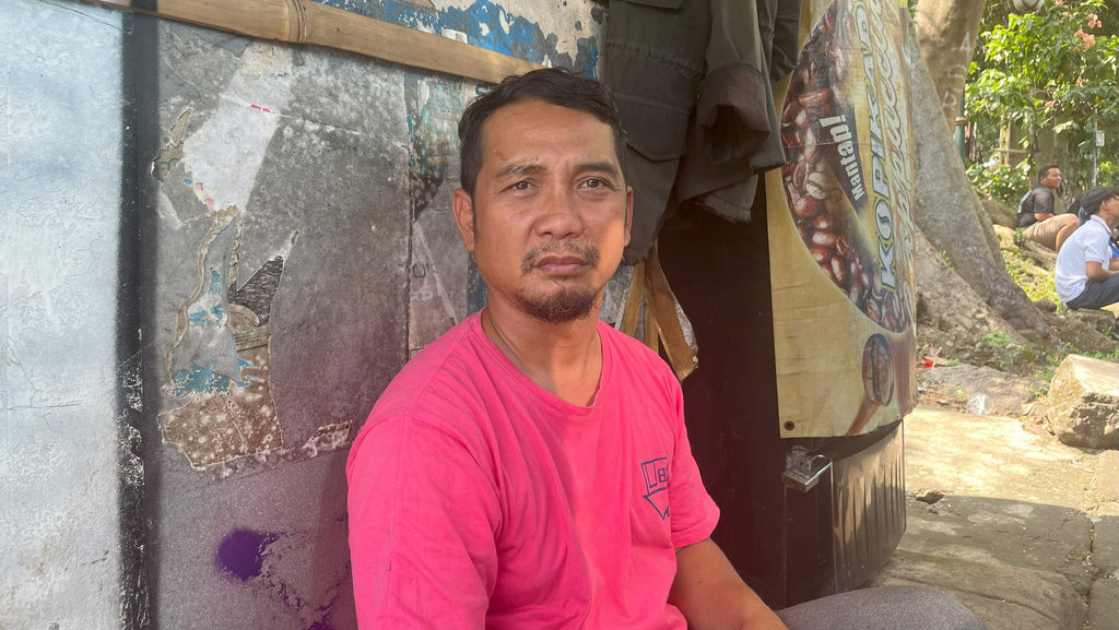 Dino (35), sopir angkot trayek Sukasari - Cisarua, sedang menunggu penumpang, Senin (23/6/2025). tirto.id/Fina Nailur Kebijakan Kompensasi Angkot ala Dedi Mulyadi