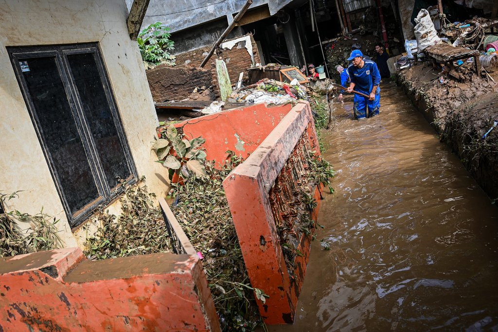 Petugas Dinas Sumber Daya Air membersihkan material banjir di kawasan permukiman di Kramat Jati, Cawang, Jakarta, Senin (7/7/2025). ANTARA FOTO/Sulthony Hasanuddin/foc. Banjir berangsur surut di Jakarta