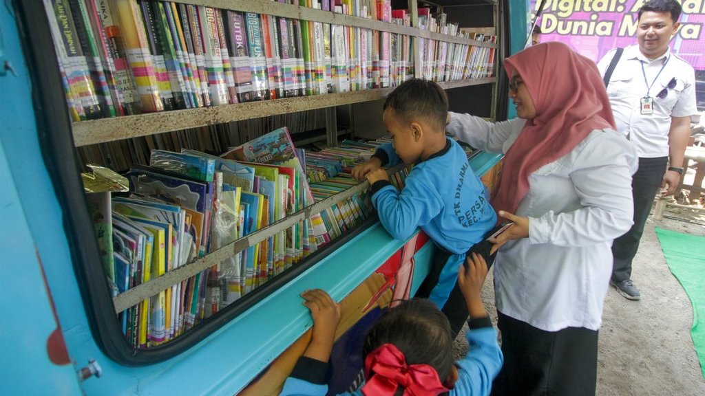 Petugas mendampingi anak memilih buku di Mobil Perpustakaan Keliling di Sidoarjo, Jawa Timur, Senin (28/7/2025). ANTARA FOTO/Umarul Faruq/bar Upaya meningkatkan minat membaca pada anak