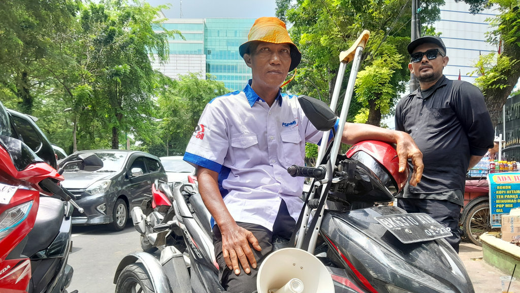 Dedi Heriawan, buruh disabilitas asal Kabupaten Deli Serdang, mengikuti aksi demonstrasi di luar gedung DPRD Sumatera Utara, Kota Medan, Kamis (28/8/2025). (Tirto.id/Nanda Fahriza Batubara) Aksi Demo Buruh di DPRD Sumatera Utara