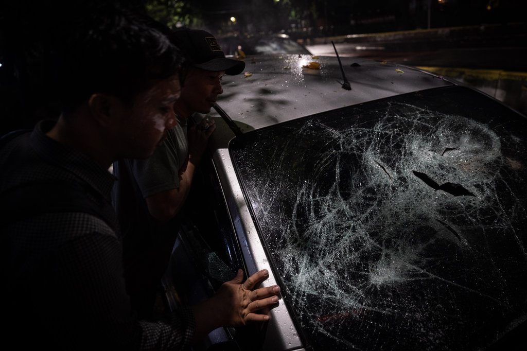 Warga melihat mobil yang rusak saat aksi unjuk rasa di depan Markas Komando (Mako) Brimob Polda Mtero Jaya, Kwitang, Jakarta, Jumat (29/8/2025). ANTARA FOTO/Bayu Pratama S/wpa. Aksi demo di depan Mako Brimob Kwitang