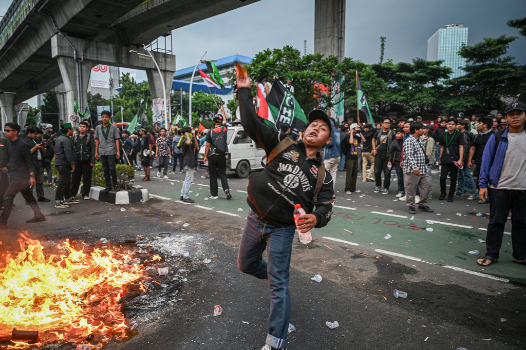 Pengunjuk rasa melempar air kemasan saat aksi di depan Mabes Polri, Jakarta, Jumat (29/8/2025). ANTARA FOTO/Fauzan/nym. Aksi di Mabes Polri