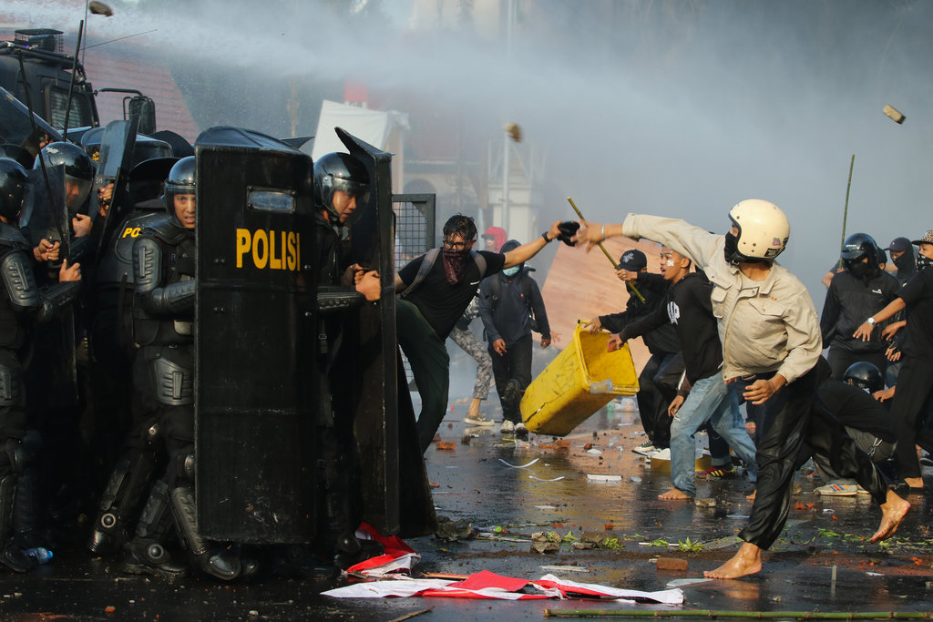 Sejumlah anggota polisi bertahan dari lemparan batu pengunjuk rasa di Jalan Gubernur Suryo, Surabaya, Jawa Timur, Jumat (29/8/2025). ANTARA FOTO/Didik Suhartono/rwa. Unjuk rasa kasus tewasnya Affan Kurniawan di Surabaya