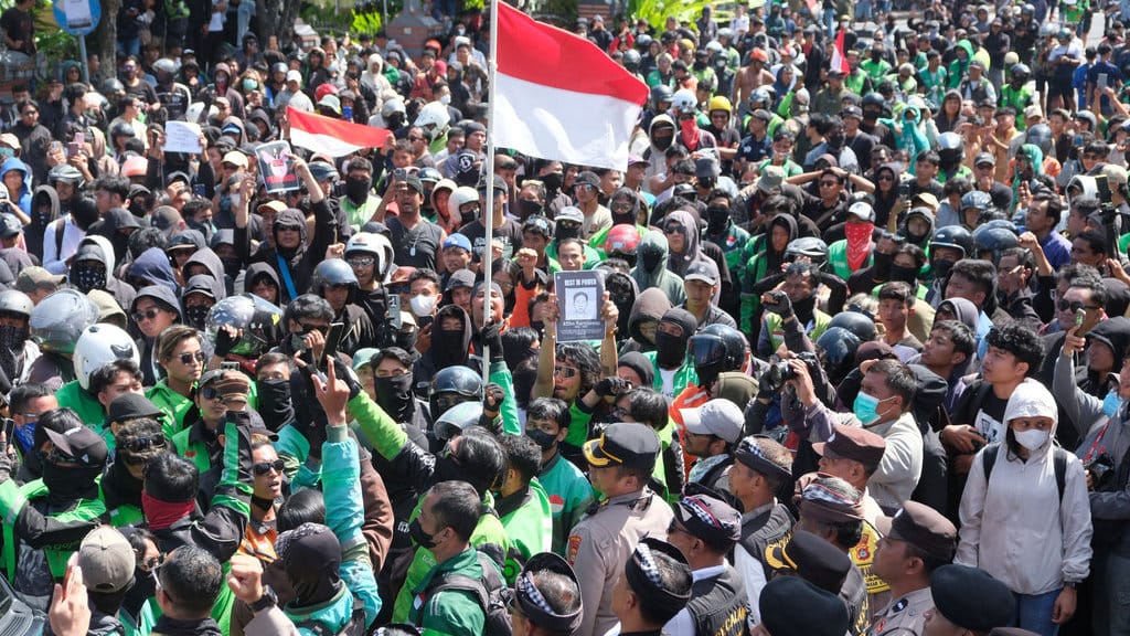 Massa dari gabungan mahasiswa dan pengemudi ojek daring menyanyikan lagu Indonesia Raya saat unjuk rasa di depan Polda Bali, Denpasar, Bali, Sabtu (30/8/2025). Kapolda Bali Irjen Pol. Daniel Adityajaya meminta personel mengutamakan pendekatan persuasif dalam mengawal aksi demonstrasi dari sejumlah elemen masyarakat sipil. ANTARA FOTO/Nyoman Hendra Wibowo/YU Unjuk rasa di Polda Bali
