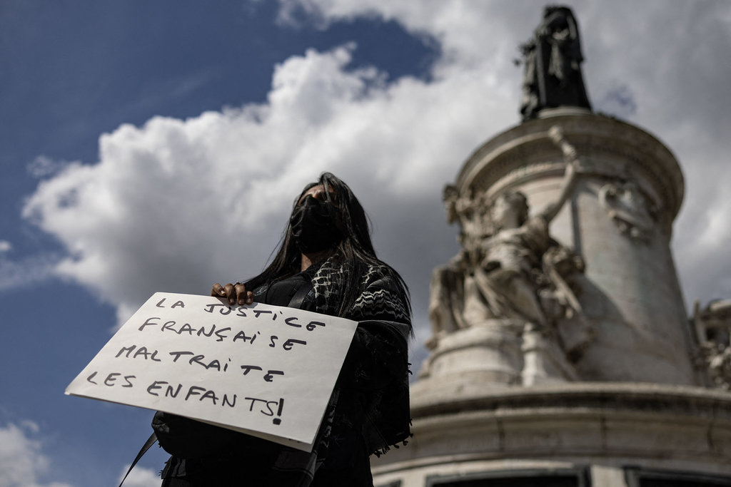 Seorang pengunjuk rasa memegang plakat bertuliskan 'Sistem hukum Prancis menganiaya anak-anak' dalam unjuk rasa 'Ibu-Ibu yang Marah' di Place de la Republique, Paris, pada 9 September 2025. AFP/Ian LANGSDON Situasi Unjuk Rasa Prancis