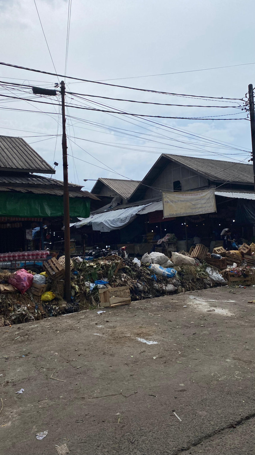 Kondisi tumpukan sampah di TPS Pasar Induk Caringin, Kota Bandung yang masih menggunung, pada pertengahan Oktober 2025 lalu. Sejumlah tumpukan sampah pun tampak di depan kios pedagang. tirto.id/Amad NZ TPS Pasar Induk Caringin