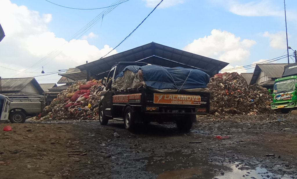 Kondisi tumpukan sampah di TPS Pasar Induk Caringin, Kota Bandung yang masih menggunung, pada pertengahan Oktober 2025 lalu. Sejumlah tumpukan sampah pun tampak di depan kios pedagang. tirto.id/Amad NZ TPS Pasar Induk Caringin