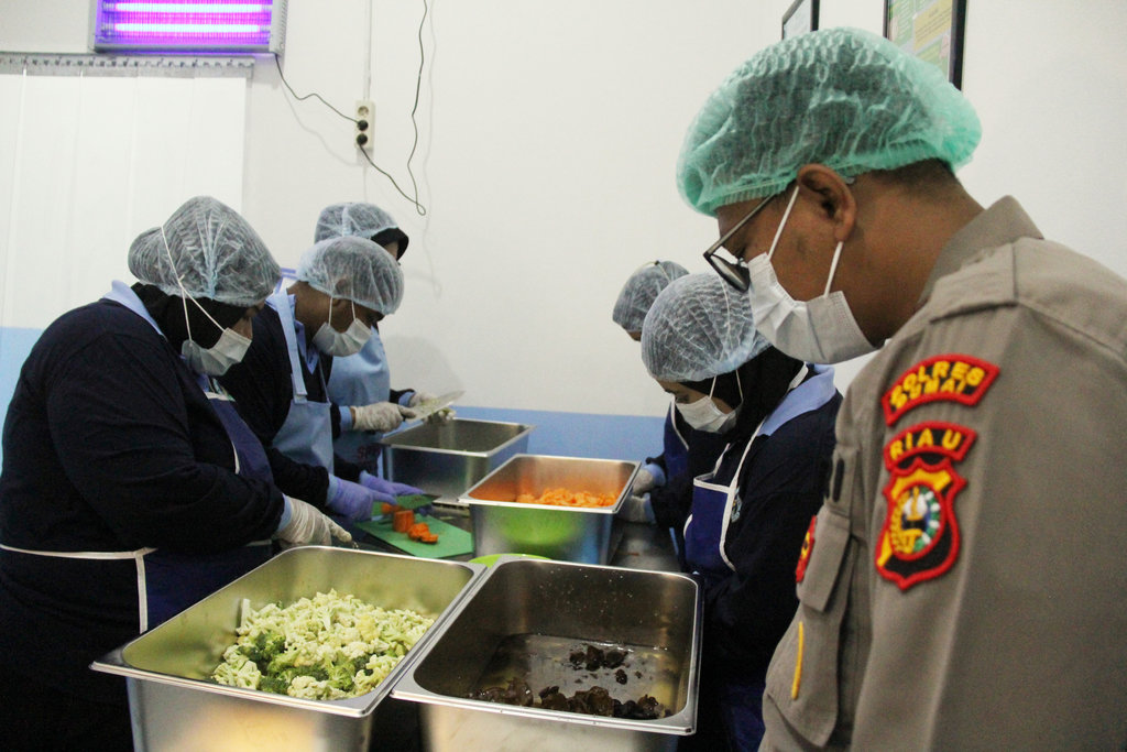 Anggota Polri mengawasi pekerja mengolah bahan makanan untuk program Makan Bergizi Gratis (MBG) saat simulasi pengoperasian dapur Satuan Pelayanan Pemenuhan Gizi (SPPG) Polri di Dumai, Riau, Selasa (11/11/2025). Simulasi SPPG Polri untuk Kecamatan Dumai Selatan tersebut melibatkan anggota Polres Dumai dan diawasi oleh petugas Puskesmas dan KPPG untuk mendapatkan Sertifikat Laik Higiene Sanitasi (SLHS) dan selanjutnya akan dibangun SPPG Polri untuk Daerah 3T di wilayah itu. ANTARA FOTO/Aswaddy Hamid/tom. Simulasi SPPG Polri di Dumai