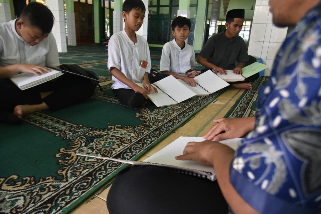 Sejumlah siswa penyandang disabilitas tunanetra SLBN A Pajajaran, saat membaca Al Quran braille di Masjid Ibnu Ummi Maktum Sentra Wyataguna, Kota Bandung, pekan lalu. tirto.id/Amad NZ. Newsplus Kisah Pembaca Al-Quran Braille