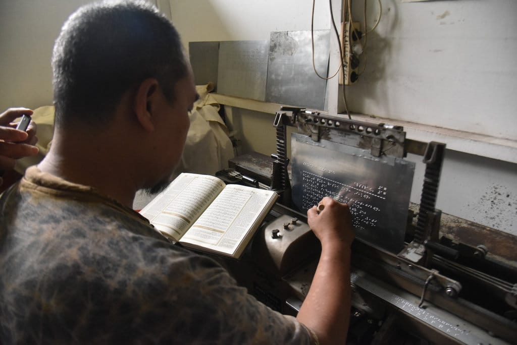 Seorang pekerja menyelesaikan pembuatan Al Quran Braille di ruang produksi Yayasan Penyantun Wyata Guna, Kota Bandung, pekan lalu. tirto.id/Amad NZ. Newsplus Kisah Pembaca Al-Quran Braille