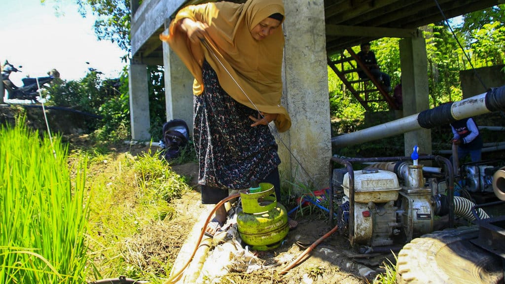 Mainizar (51) menarik tali engkol pada mesin pompa air di area persawahan desa Lampanah Tunong, Indrapuri, Aceh Besar. Foto : Firhan Farabi/tirto.id Gas Subsidi untuk persawahan
