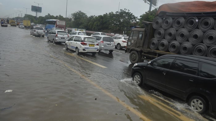 Sejumlah kendaraan berjalan tersendat ketika melintasi banjir yang menggenangi sebagian jalan tol di sekitar Jati Bening, Bekasi, Jabar, Selasa (21/2). Hujan lebat yang terjadi beberapa hari ini menyebabkan sejumlah tempat di Jakarta, Bekasi, dan Tangerang tergenang air. ANTARA FOTO/Saptono/Spt/17