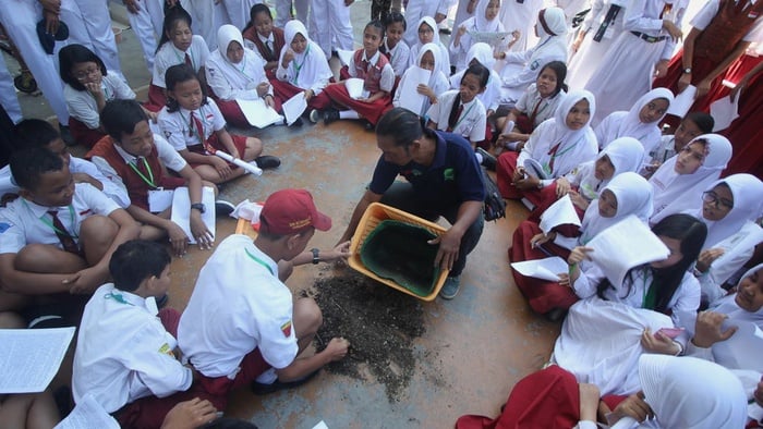Sejumlah murid kelas 7 Sekolah Menengah Pertama (SMP) Negeri 19 Surabaya melihat isi komposter saat mengikuti Layanan Orientasi Siswa (LOS) di halaman sekolah mereka di Surabaya, Jawa Timur, Senin (17/7). ANTARA FOTO/Moch Asim