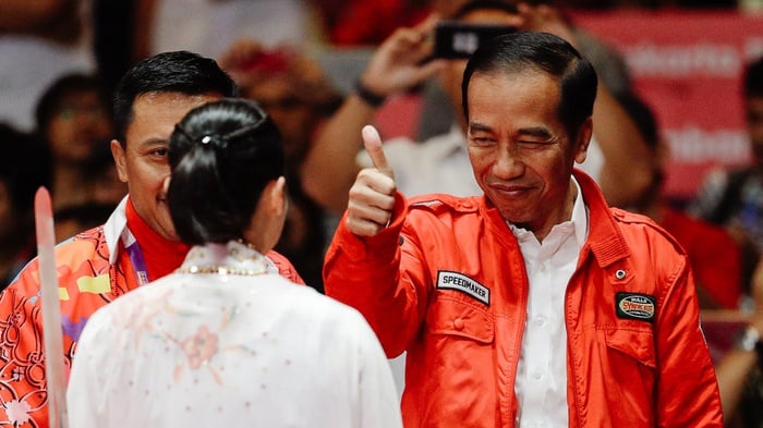 Presiden Indonesia Joko Widodo memberi ancungan jempol saat  Lindswell Kwok, atlet wushu Indonesia setelah penampilannya di nomor cabang Taijijian Putri Wushu Asian Games 2018 di JIExpo Kemayoran, Jakarta, Senin (20/8/18). AP Photo / Aaron Favila