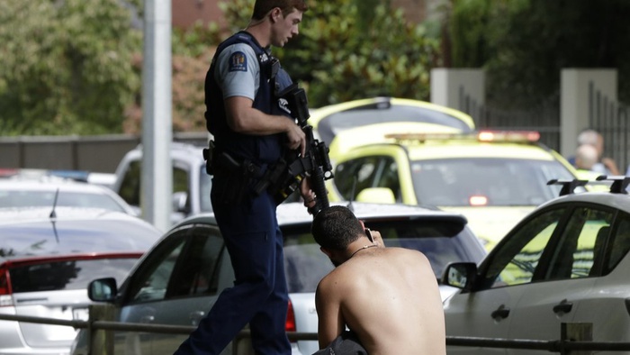 Seorang pria bersandar di tanah ketika ia berbicara di telepon genggamnya di seberang jalan dari masjid di pusat Christchurch, Selandia Baru, Jumat, 15 Maret 2019.  Mark Baker / AP