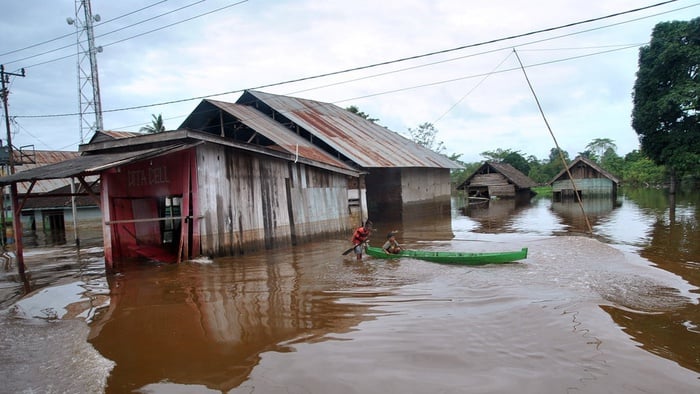 Anak-anak menaiki sampan saat banjir di jalan Poros Kendari, Pondidaha, Kabupaten Konawe, Sulawesi Tenggara, Kamis (20/6/2019). ANTARA FOTO/Arif Firmansyah/aww.