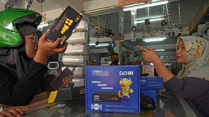 Pedagang alat elektronika menjelaskan fungsi perangkat set top box (STB) kepada warga di Pasar Induk Rau Kota Serang, Banten, Selasa (8/11/2022). ANTARA FOTO/Asep Fathulrahman/aww.